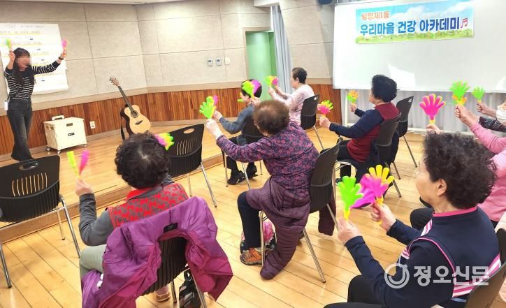 어르신들이 손바닥 짝짝이를 흔들며 리듬을 맞추고 있는 모습