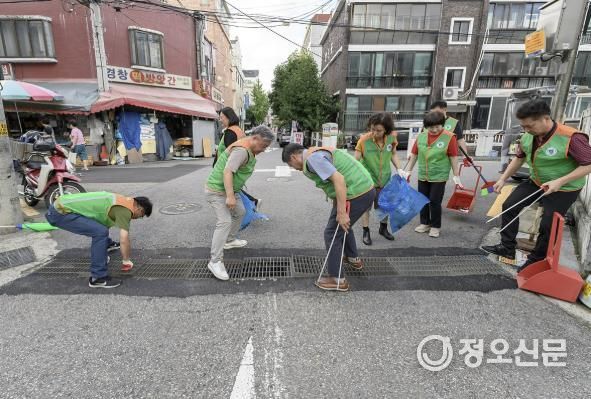 지난해 배수로 안에 쌓인 쓰레기를 줍고 있는 양천구 자율방재단